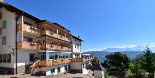 un gran edificio con balcones en un lateral en Hotel & Gasthof zum Hirschen, en San Genesio Atesino