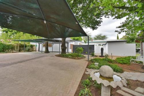 un grand parasol vert devant un bâtiment dans l'établissement De Witte Huis, à Bethlehem