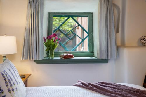 Un dormitorio con una ventana con un jarrón de flores en Inn of the Turquoise Bear, en Santa Fe