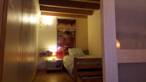 ein kleines Zimmer mit einem Bett und einem Spiegel in der Unterkunft Le Chalet du Parc in Annonay