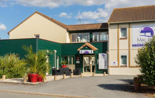 um edifício com uma loja com uma fachada verde em Hôtel Mac Bed em Poitiers