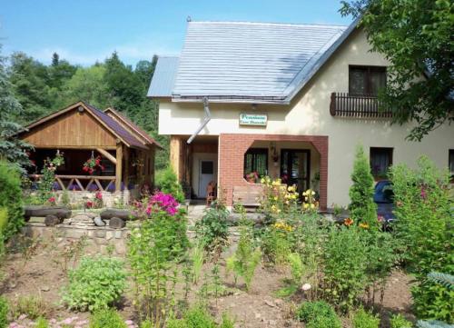 a house with a garden in front of it at Pensiunea Casa Domniței Sucevița in Suceviţa