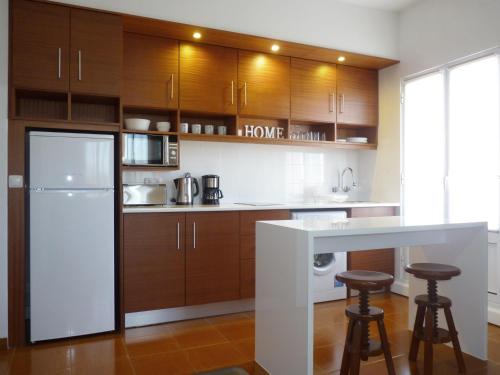 una cucina con armadi in legno e frigorifero bianco di Home for Travellers ll a Ponta Delgada