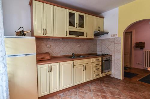 een keuken met witte kasten en een witte koelkast bij Lux Apartman Cvetkovic in Kraljevo