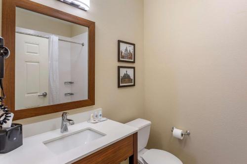 La salle de bains est pourvue d'un lavabo, de toilettes et d'un miroir. dans l'établissement Comfort Suites, à Clarksville