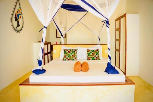 una camera da letto con un letto con due scarpe sopra di Mnana Beach Bungalows a Michamvi Kae