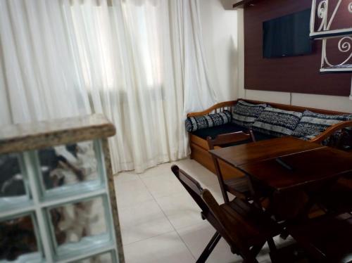 a living room with a table and a couch at Cond. Hotel Âncora em frente Praia do Peró in Cabo Frio