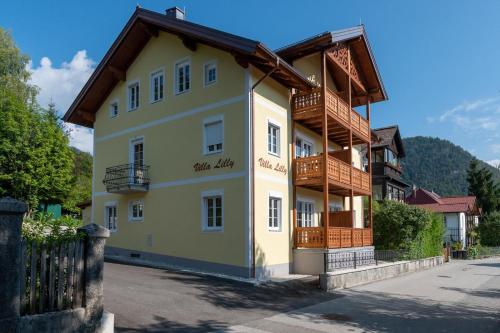 un grande edificio giallo con tetto in legno di Villa Lilly - Luxus Appartements im Villenviertel a Bad Ischl