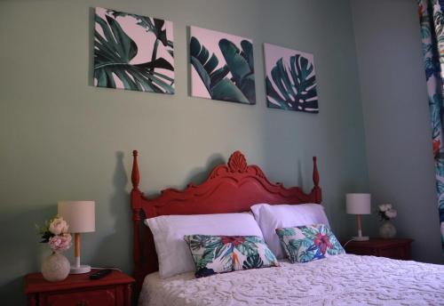 a bedroom with a bed with four pictures on the wall at Casa da Nonô in Coimbra