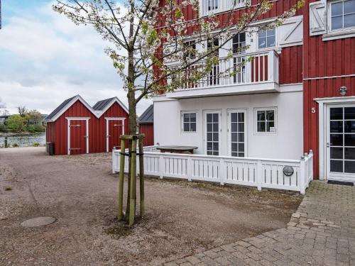 een rood-wit huis met een boom ervoor bij Holiday home Gråsten LXVIII in Gråsten