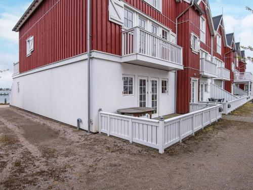 een rood-wit gebouw met een bank op de veranda bij Holiday home Gråsten LXVIII in Gråsten