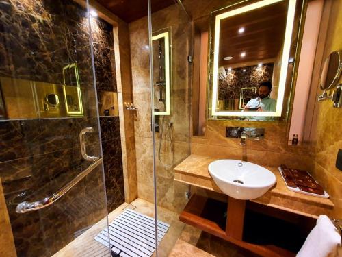 a bathroom with a sink and a shower at Hotel MBC Citadel Nashik in Nashik