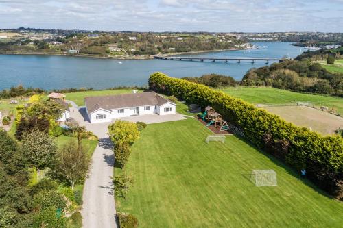 Vue aérienne d'une maison sur une pelouse à côté d'une rivière dans l'établissement Marina views, Kinsale, Exquisite holiday homes, sleeps 20, à Kinsale