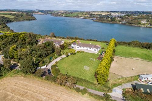 - une vue aérienne sur une grande maison sur un champ à côté d'un lac dans l'établissement Marina views, Kinsale, Exquisite holiday homes, sleeps 20, à Kinsale