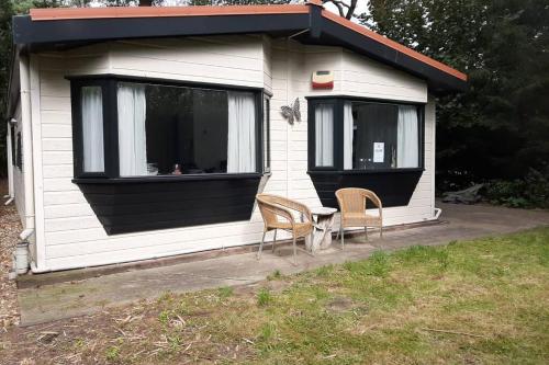 een klein huis met twee stoelen en een tafel erin bij Chalet "de Hazelnoot" te Diever in Diever