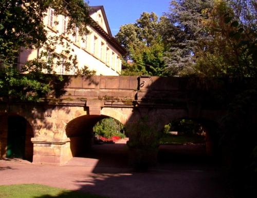 un ponte di pietra con archi di fronte a un edificio di Kurpark-Residenz Deidesheim a Deidesheim