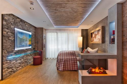 Habitación de hotel con cama y chimenea en PETE Alpine Boutique Hotel - klein und fein - Private SPA Suiten und Zimmer, en Sankt Anton am Arlberg