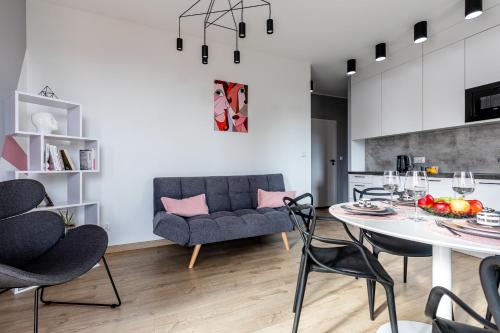 een keuken en een woonkamer met een tafel en stoelen bij Apartament Old Town Nest in Gdańsk