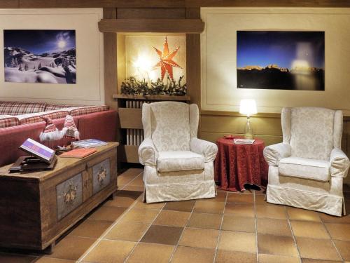 sala de estar con 2 sillas y mesa en Hotel Bertelli, en Madonna di Campiglio