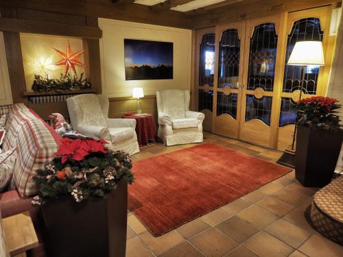 sala de estar con 2 sillas y alfombra roja en Hotel Bertelli, en Madonna di Campiglio