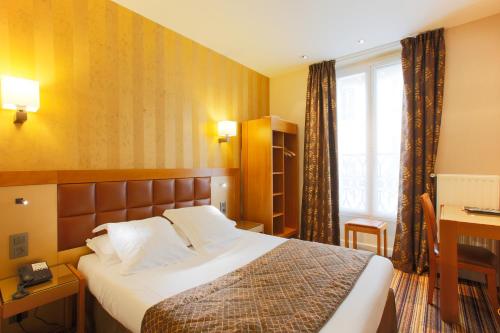 a hotel room with a bed and a window at Hotel Bellevue Saint-Lazare in Paris