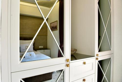 a cabinet with a mirror in a bedroom at Villa Giardino Heritage Boutique Hotel Bol in Bol