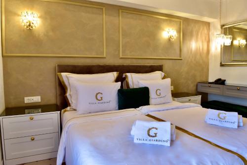 a hotel room with two beds with white sheets at Villa Giardino Heritage Boutique Hotel Bol in Bol