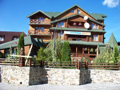 un grand bâtiment en bois avec un panneau. dans l'établissement Urochyshe Vyshnya, à Bukovel