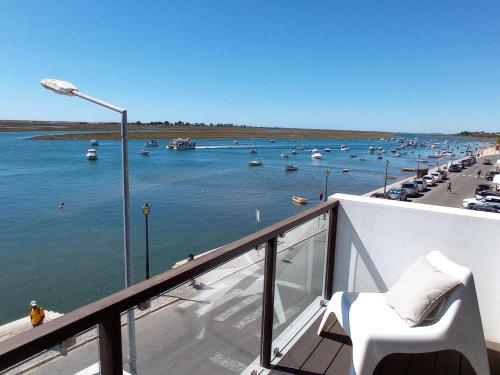 uma varanda com vista para um porto com barcos na água em Flamingo Beach House em Santa Luzia