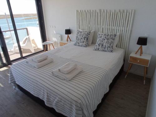 um quarto com uma cama com duas toalhas em Flamingo Beach House em Santa Luzia