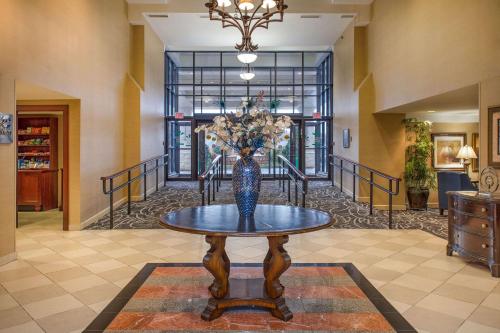 a vase of flowers on a table in a hallway at Clarion Collection Hotel Arlington Court Suites in Arlington