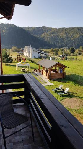 um banco de madeira sentado em cima de um campo em Casa Alesia Bucovina em Gura Humorului