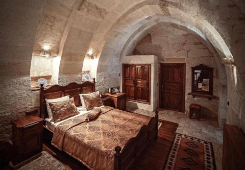 een slaapkamer met een groot bed in een stenen kamer bij Melis Cave Hotel in Urgup