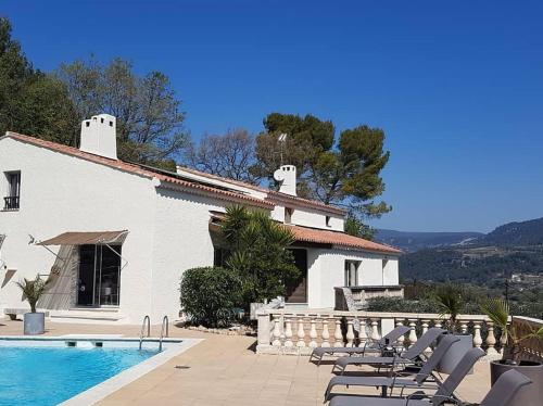 ein Haus mit Pool und Stühlen daneben in der Unterkunft Villa Manoe in Draguignan