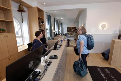 Una donna in piedi in una biblioteca che guarda i computer di Hotel Bethel a Copenaghen