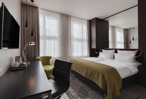 Holiday Inn Dresden - Am Zwinger, an IHG Hotel في درسدن: غرفة نوم بسرير ومكتب وكرسي