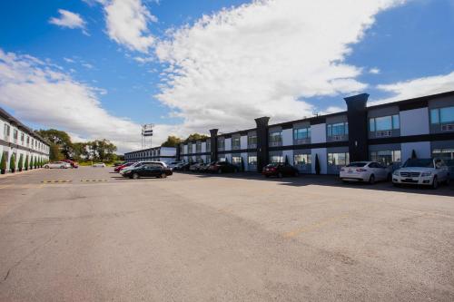 un parking avec des voitures garées devant un bâtiment dans l'établissement Hotel Newstar Montréal, à Montréal