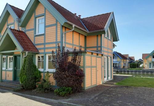 une maison jaune avec un toit brun dans l'établissement Ferienhaus ˋLichtblickˋ, à Rheinsberg