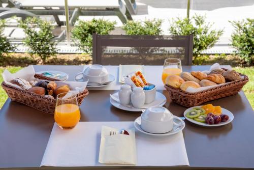 einen blauen Tisch mit Frühstückskörben und Orangensaft in der Unterkunft Luna Hotel de Tábua in Tábua