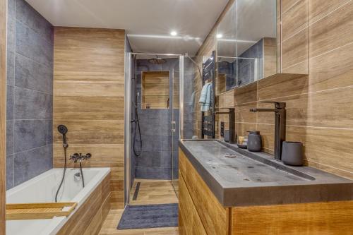 bagno con lavandino, vasca e doccia di Rare ! Appartement rénové dans le village piéton de Megève a Megève