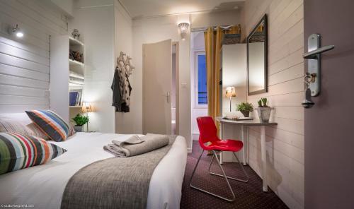 a bedroom with a bed and a red chair at Hôtel des Alpes in Annecy