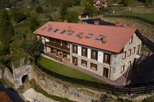 eine Luftansicht eines Hauses mit rotem Dach in der Unterkunft Apartamentos Los Picos de Europa in Colio