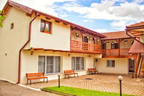 a building with benches in front of it at Pensiunea Mariana in Ocna Şugatag