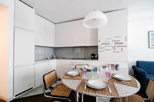 a dining room with a table and chairs and a kitchen at Downtown Como-Porta Torre Flat in Como