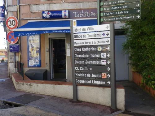 a sign in front of a building with many signs at Chez Catherine in Roquebrune-sur-Argens