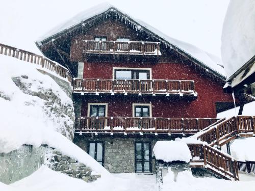 ein schneebedecktes Gebäude mit Balkon in der Unterkunft Hotel Piccolo Chalet in Claviere