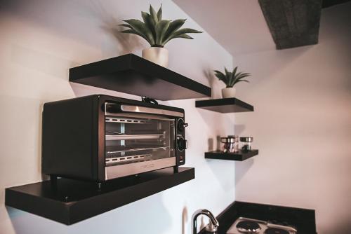 un horno tostador sentado en una pared con estanterías en The Coffee Club Apartahotel, en Manizales