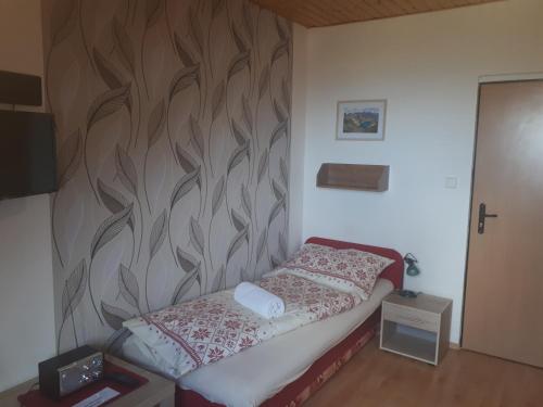 1 dormitorio con 1 cama con un mural en la pared en A1 Štart, en Starý Smokovec