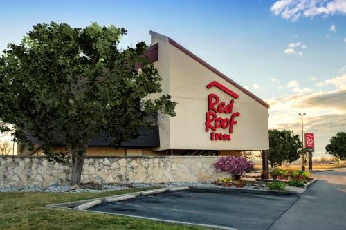 Red Roof Inn Lansing East - MSU في لانسينغ: علامة نزل ريد روك على جانب المبنى