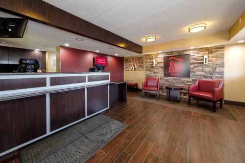 Red Roof Inn Lansing East - MSU في لانسينغ: بار مع كراسي حمراء في غرفة الانتظار